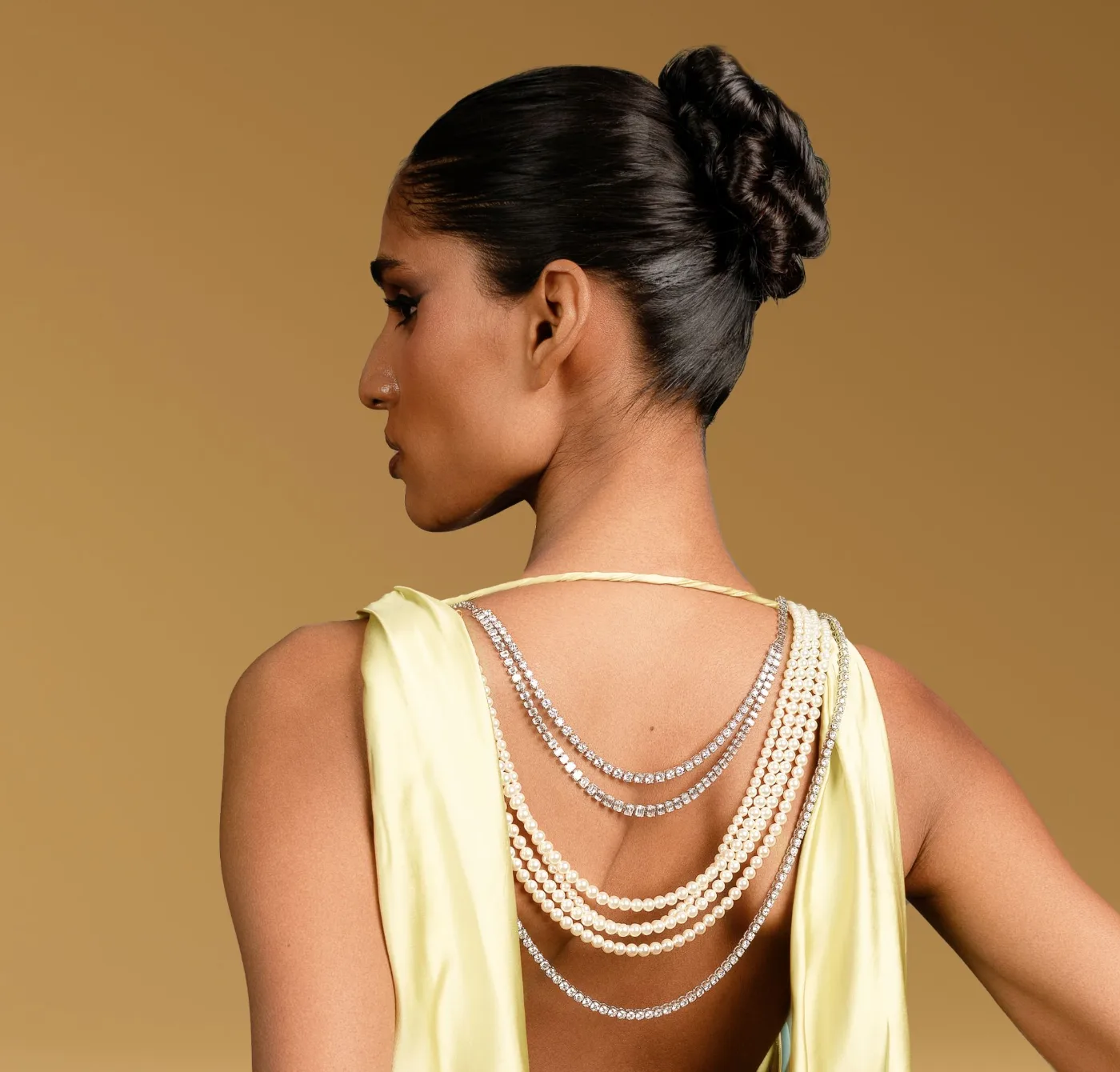 Model wearing layered diamond and pearl back necklaces