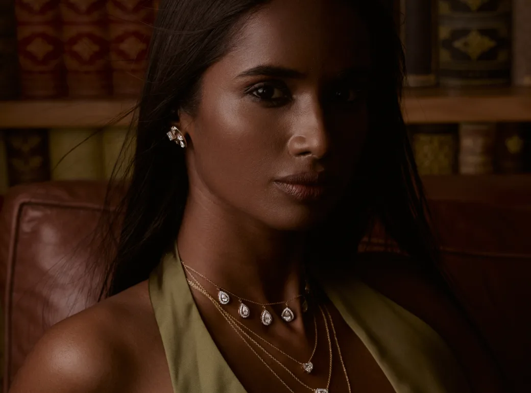 A woman in a green dress wearing Akoirah diamond necklaces and earrings