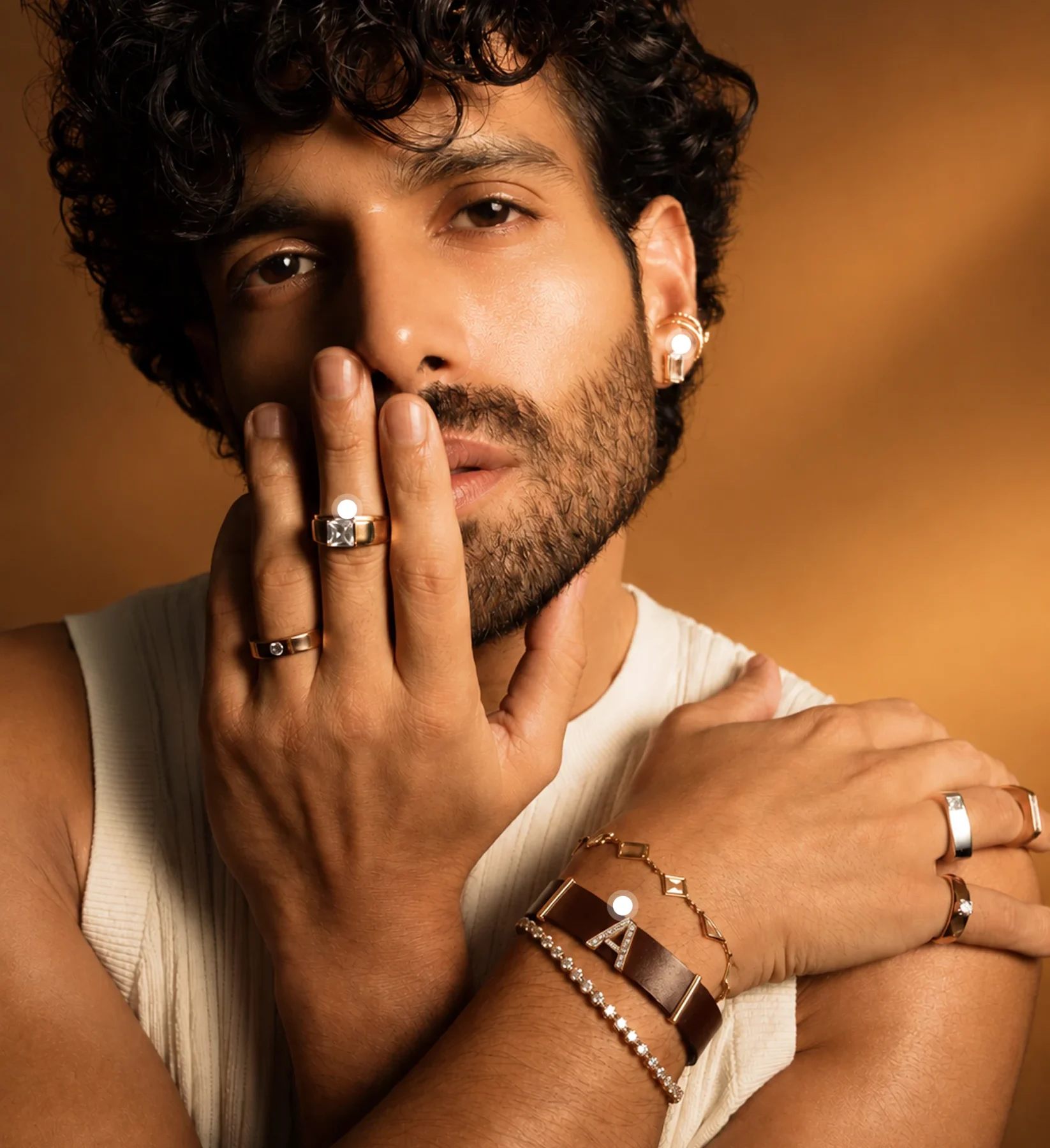 A man wearing Akoirah diamond rings, an ear cuff and bracelets